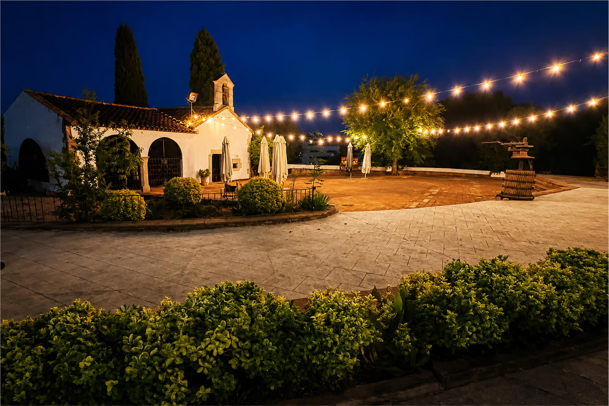 Vista nocturna del exterior de La Masia de Tordera iluminado con guirnaldas.